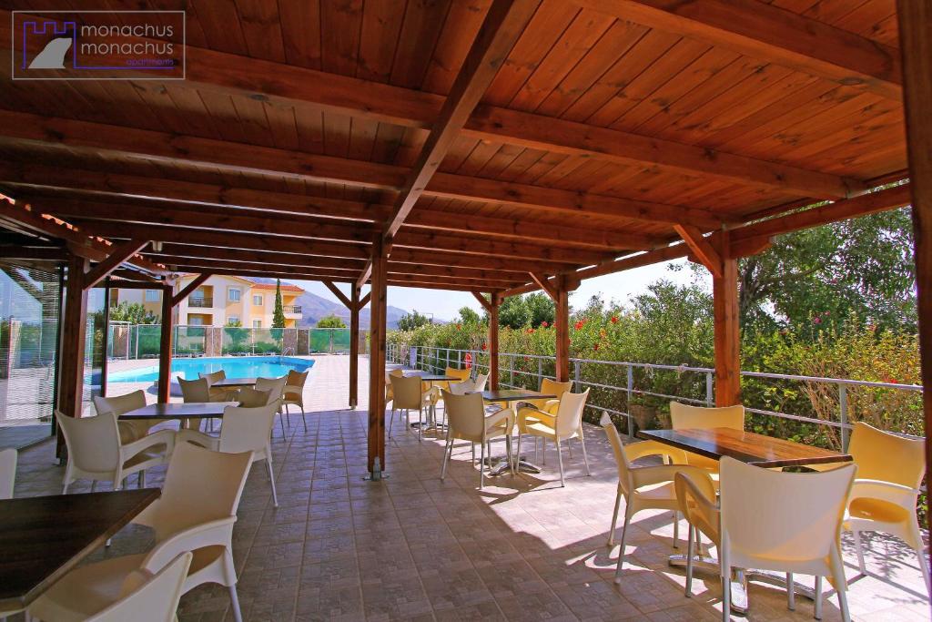 a patio with tables and chairs and a pool at Monachus Monachus in Frangokastello