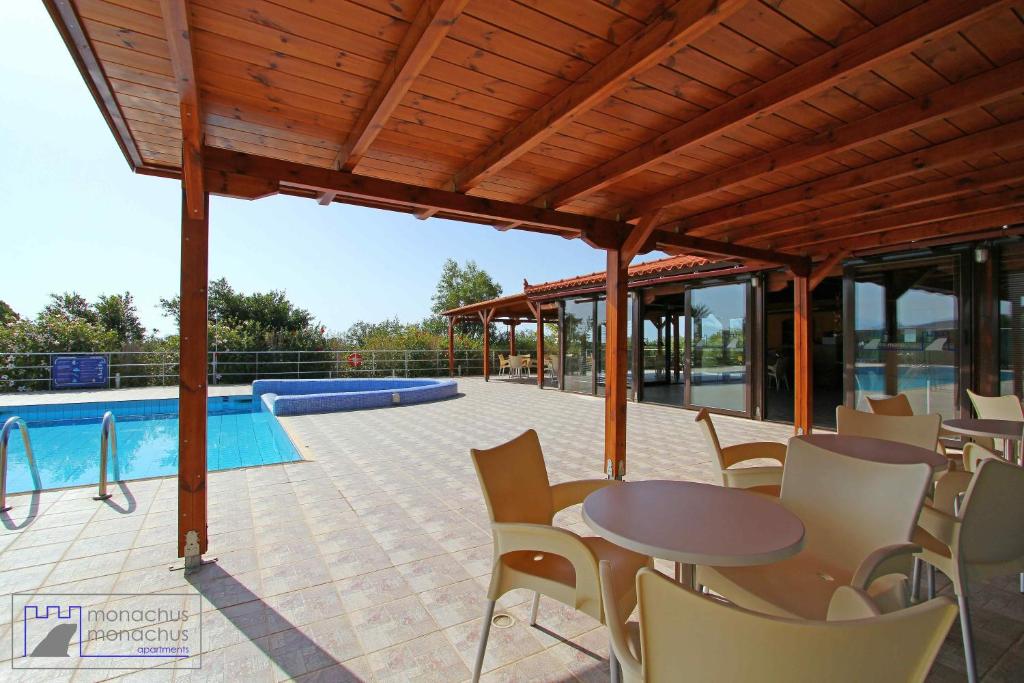 a patio with a table and chairs next to a pool at Monachus Monachus in Frangokastello