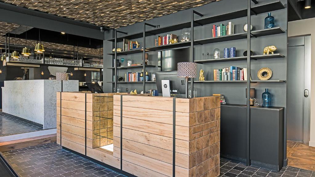 a restaurant with a wooden counter and shelves of books at ibis Styles Laval Centre Gare in Laval