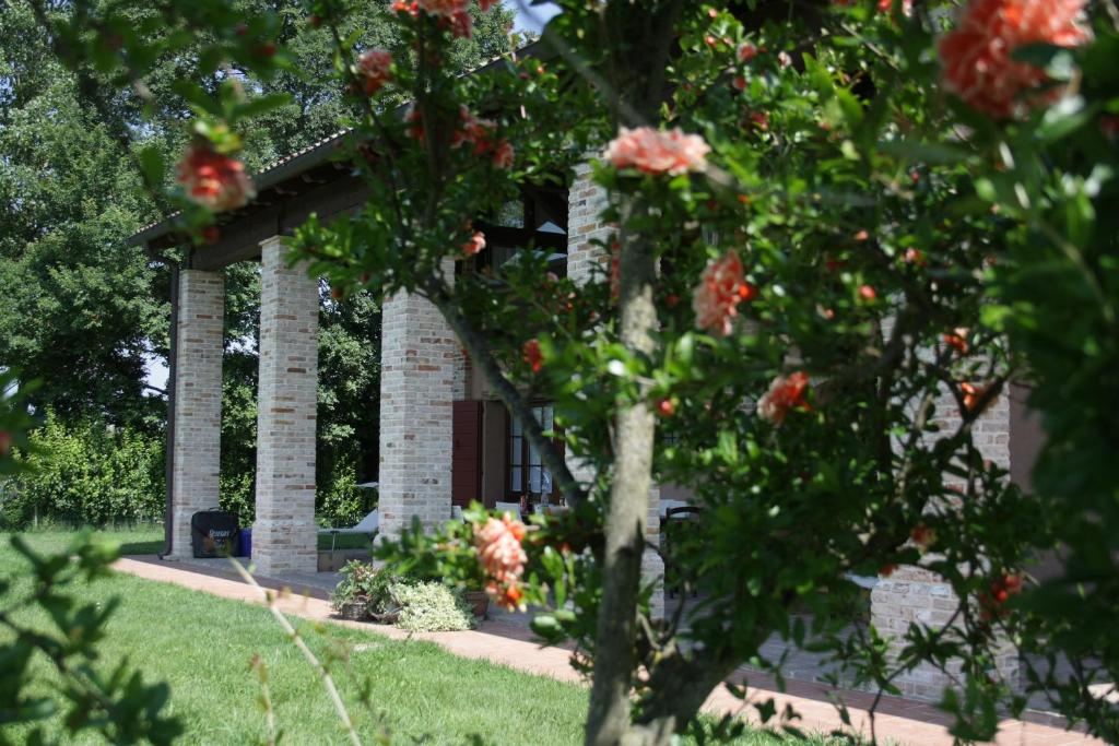 un edificio con un albero con dei fiori davanti di Agriturismo Ca' Lealtà a Marango di Caorle – Casa Pace