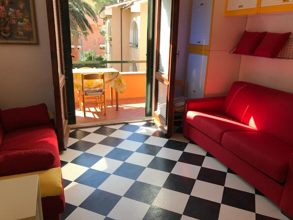 uma sala de estar com sofás vermelhos e um piso xadrez em Mono Logge em Marciana Marina