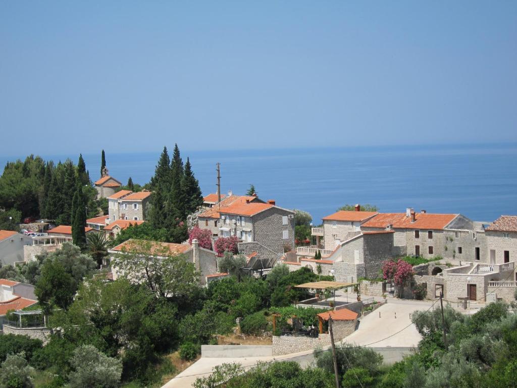 a town with houses and trees on a hill at Reževići Apartments in Petrovac na Moru