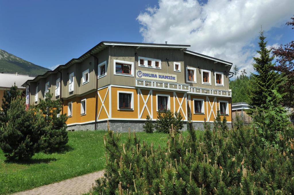 a large building in the middle of a garden at APLEND Koliba Kamzík in Vysoke Tatry - Stary Smokovec