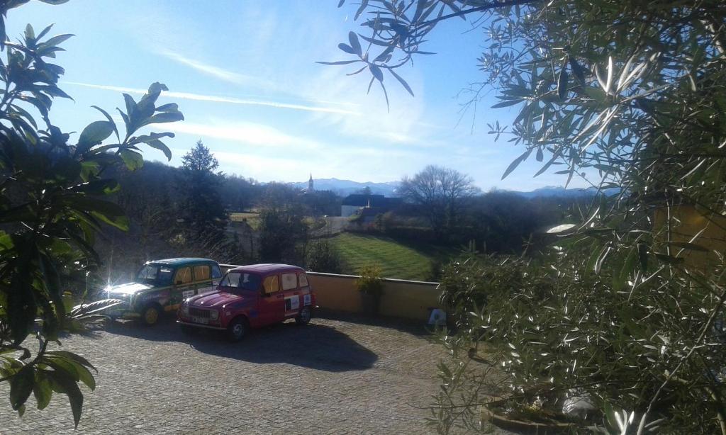 dos coches pequeños estacionados en un estacionamiento de grava en Maison Fleurie en Aubertin