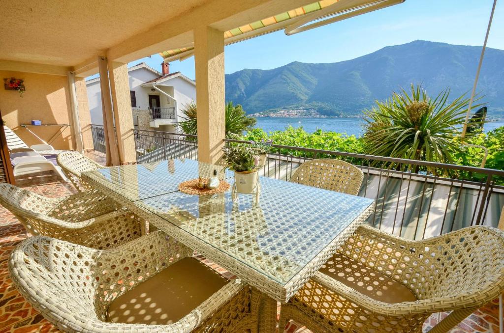 a table and chairs on a balcony with a view of the water at La Grande Apartments in Kotor