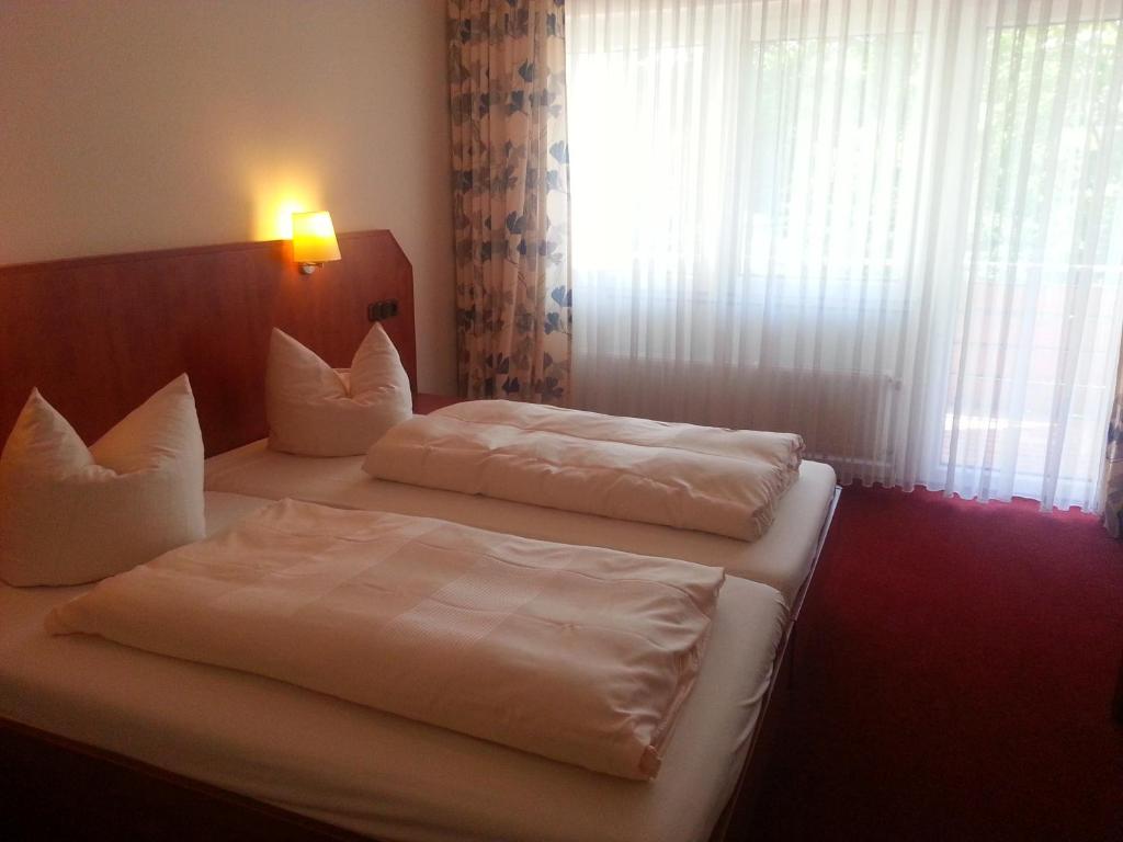 a hotel room with two beds and a window at Schmucker Jäger - Hotel Garni in Hannoversch Münden
