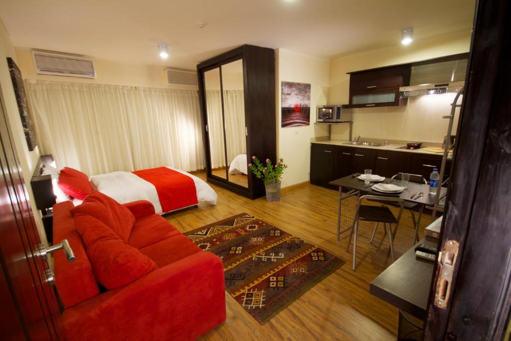 カイロにあるNewCity Hotel & Suitesのベッドと赤いソファが備わるホテルルームです。