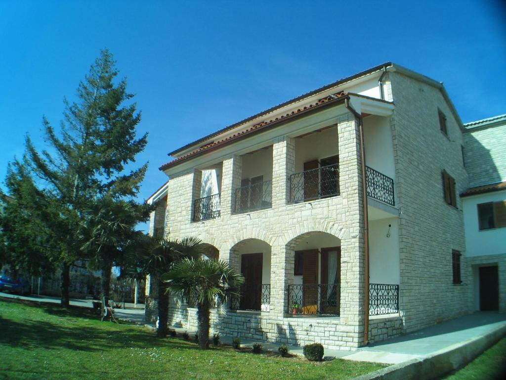 un grande edificio in mattoni con un albero di fronte di B&B Moderno a Fažana