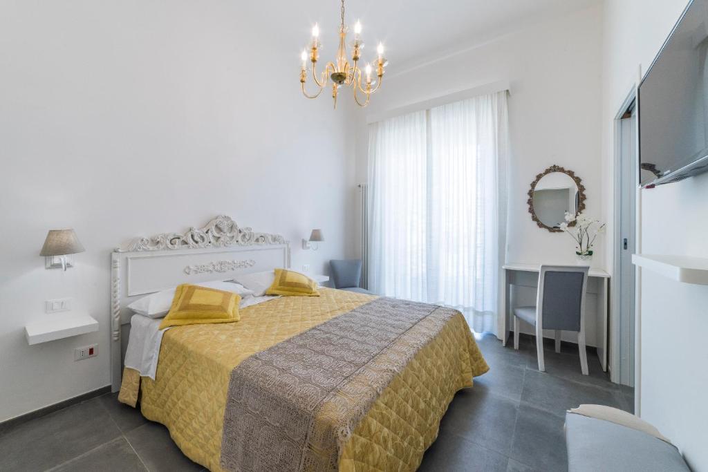 ein weißes Schlafzimmer mit einem Bett und einem Spiegel in der Unterkunft Incentro in Gallipoli