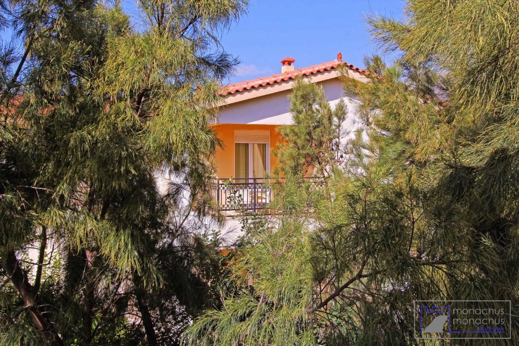a house with a balcony in the middle of trees at Monachus Monachus in Frangokastello