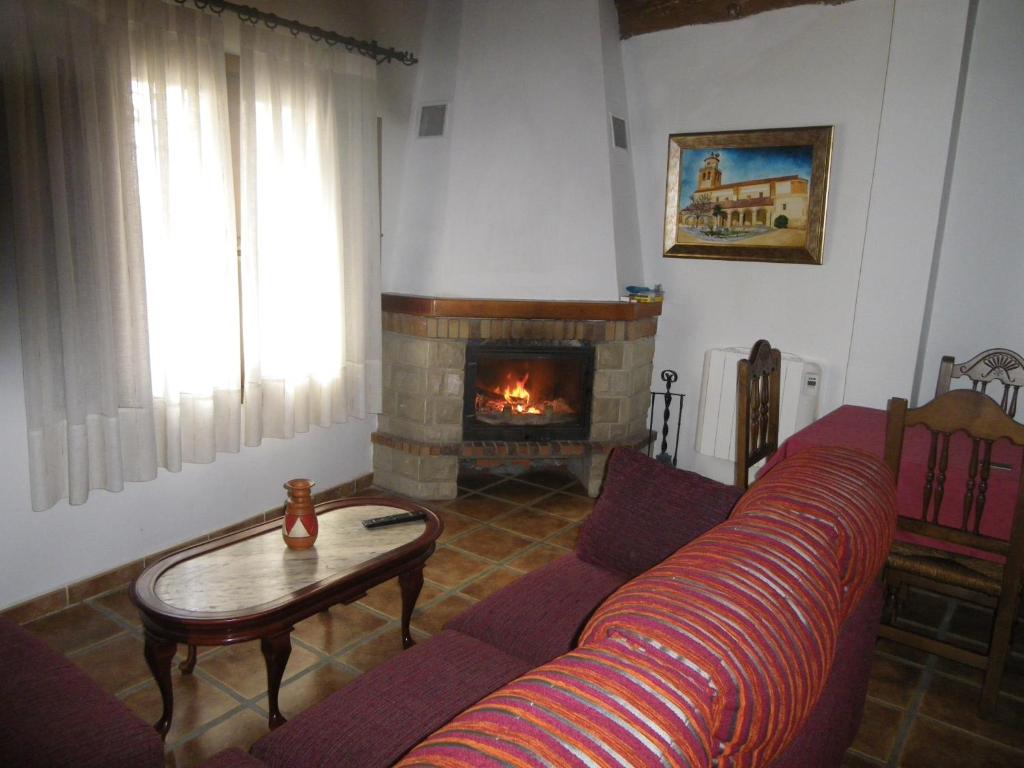 uma sala de estar com um sofá e uma lareira em Caballero de Castilla em Santiuste de San Juan Bautista