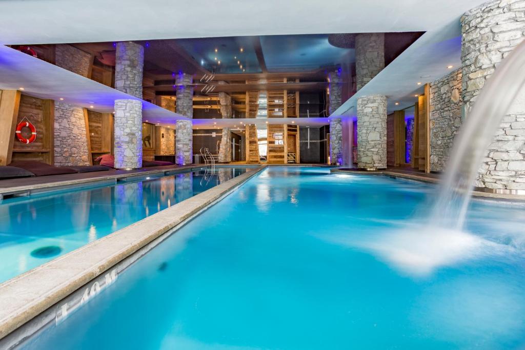 a swimming pool in a hotel with a fountain at Résidence Santa Terra in Tignes