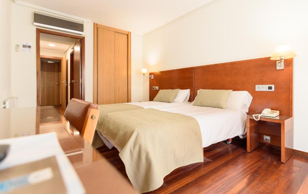 a hotel room with a large bed and a telephone at México PR in Santiago de Compostela