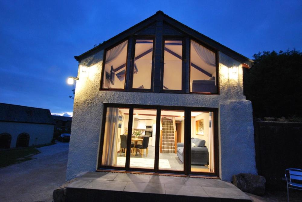 ein Haus mit großen Glasfenstern an der Seite in der Unterkunft Lakeview Cottage in Callington