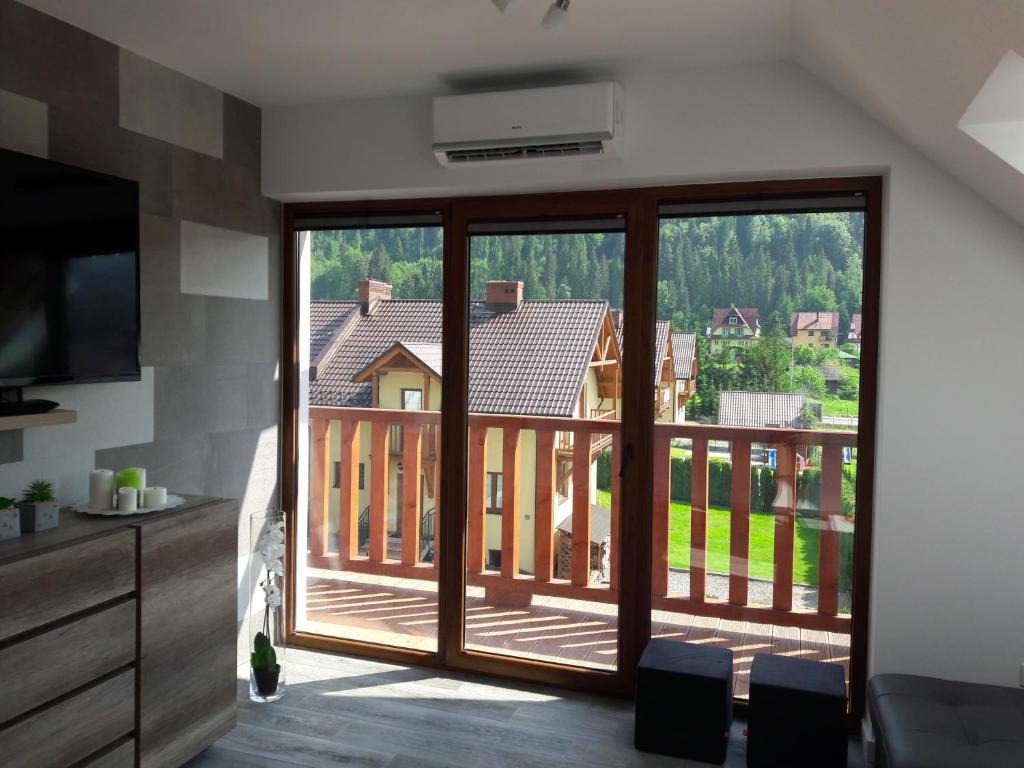 a room with a large sliding glass door with a balcony at Apartament JBF Homole in Szczawnica