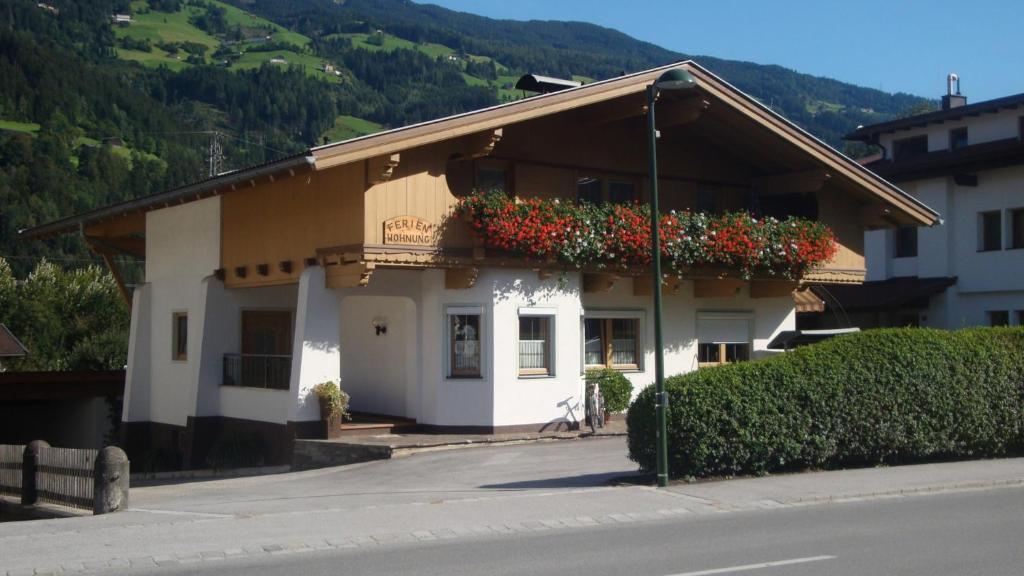 un bâtiment avec des boîtes de fleurs sur son côté dans l'établissement Haus Waldner, à Aschau