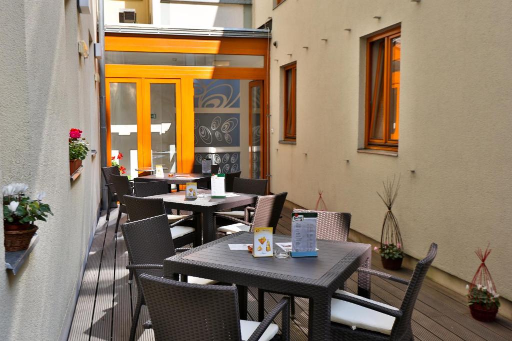 a patio with tables and chairs on a balcony at Hotel Páv in Prague