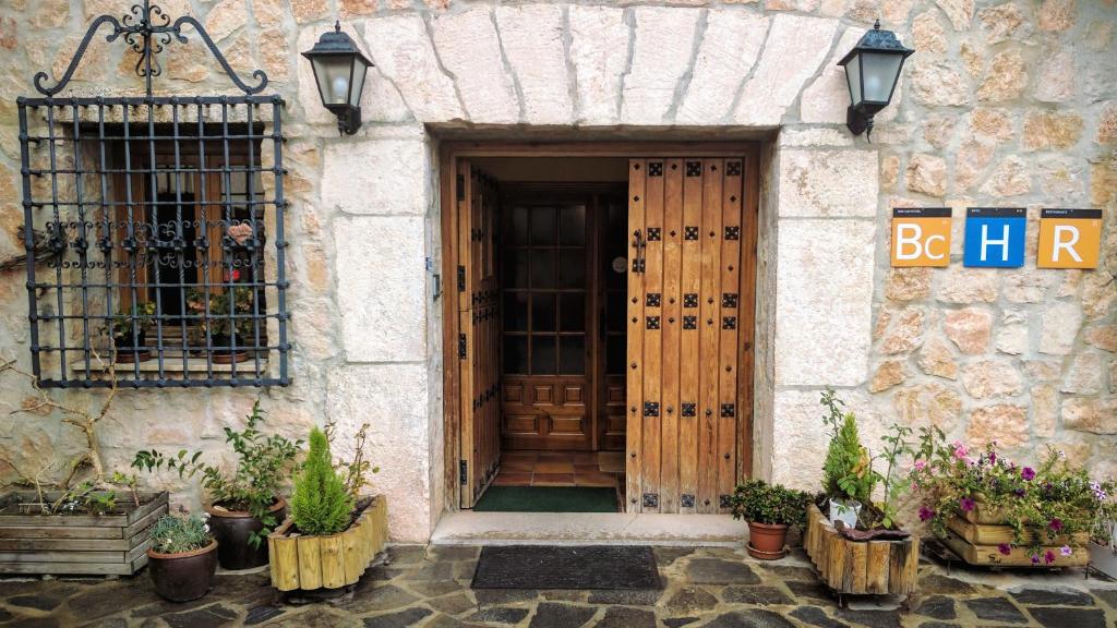 Hotel La Gerencia في Checa: باب أمام منزل به نباتات الفخار