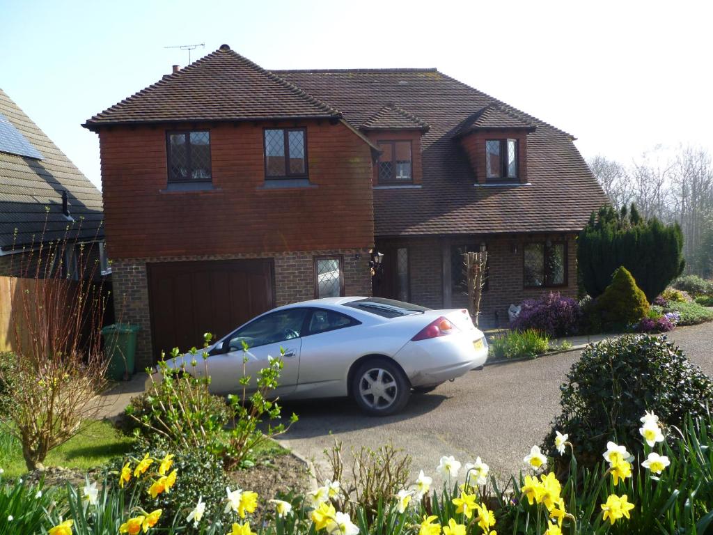 a silver car parked in front of a house at Woodpeckers Cottage B&B in Pett