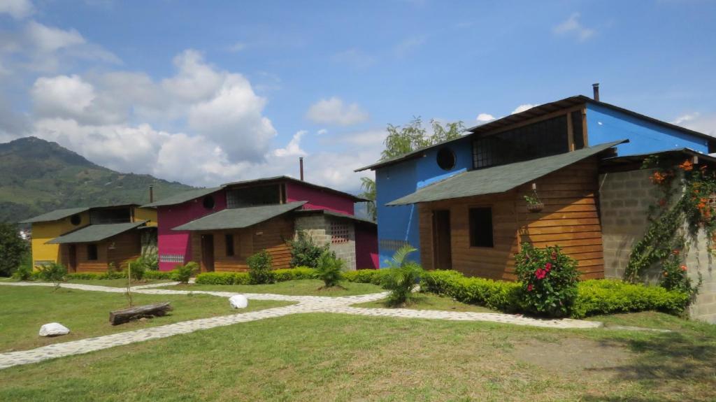 a group of houses with a grassy yard at Gallito de las Rocas Guest House in Jardin