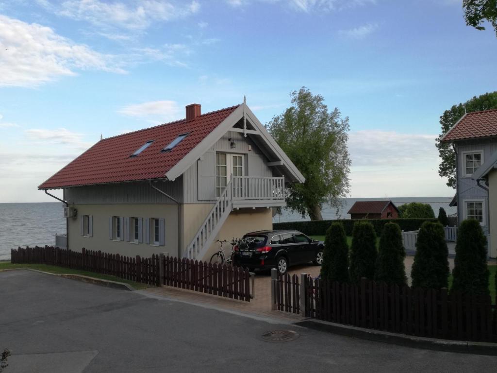 a house with a car parked in front of it at Namelis prie marių in Nida