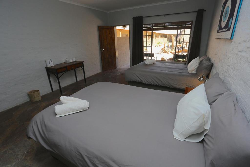 Una habitación de hotel con dos camas y una ventana. en Solitaire Roadhouse, en Solitaire