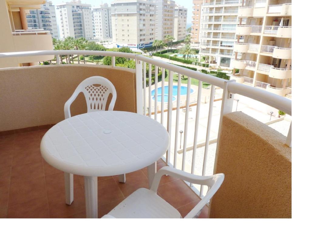 a white table and a chair on a balcony at Apartamento La Manga Del Mar Menor in La Manga del Mar Menor