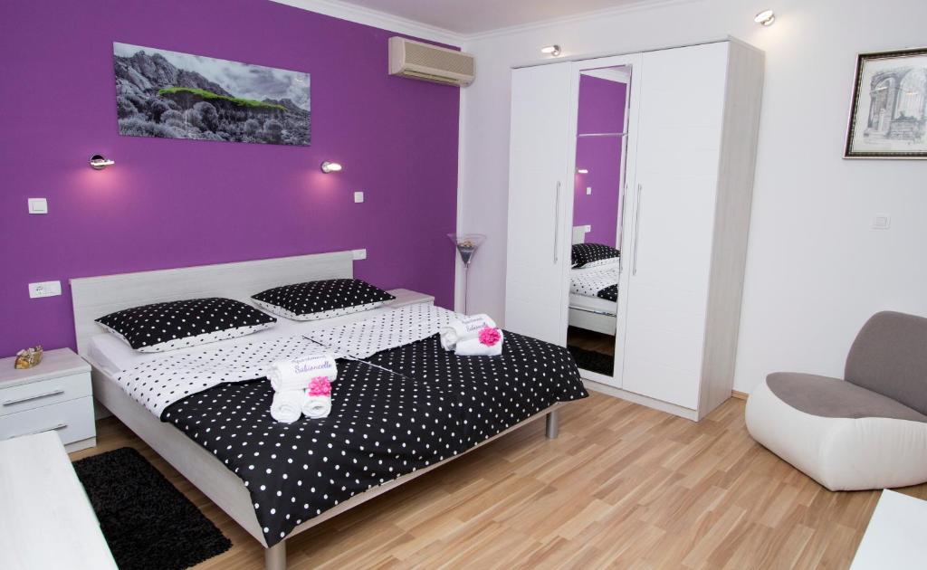 ein Schlafzimmer mit einem Bett mit einer lila Wand in der Unterkunft Apartment Sabioncello in Split