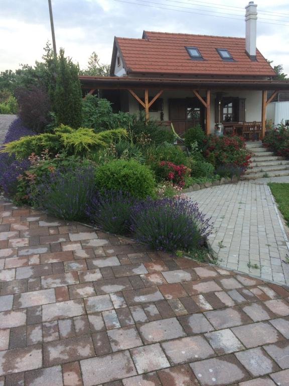 una casa con una pasarela de ladrillo frente a un jardín en Vörösmál Vendégház, en Balatonfüred