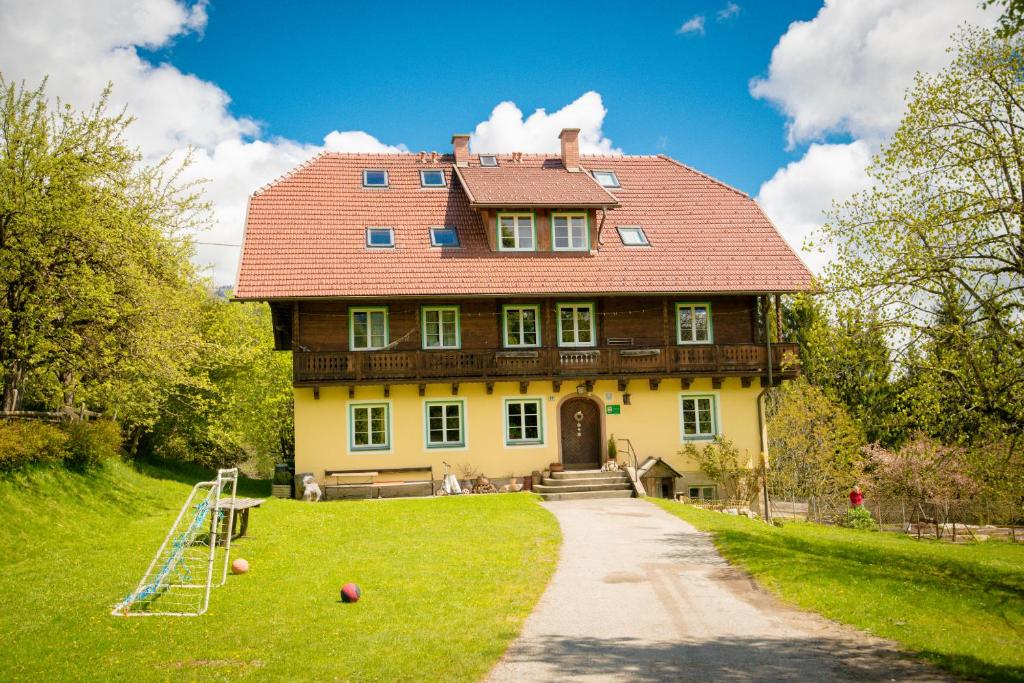 una casa grande con un parque infantil delante de ella en Walcherhof, en Arriach