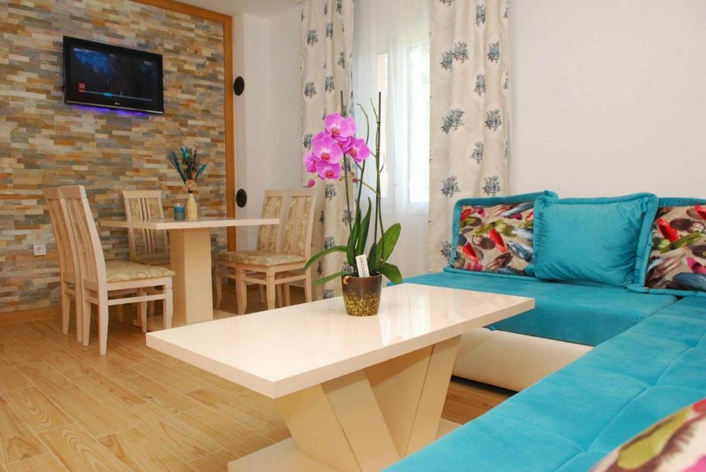 un soggiorno con divano blu e tavolo di Apartments Kuc a Tivat