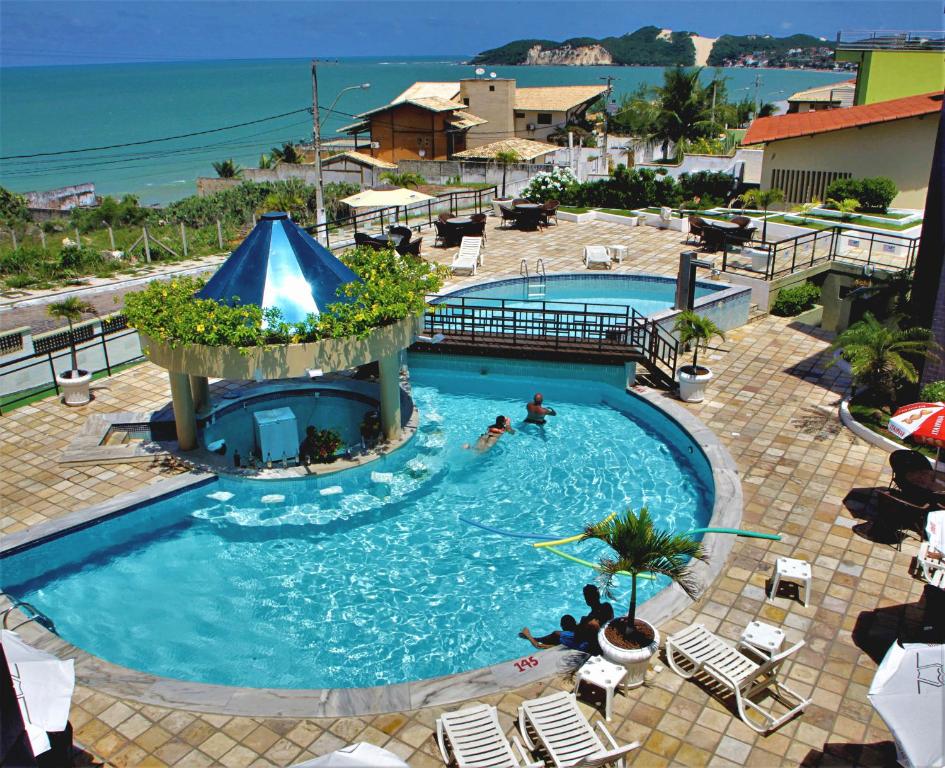 een groot zwembad met mensen in het water bij Hotel Costa do Atlantico in Natal