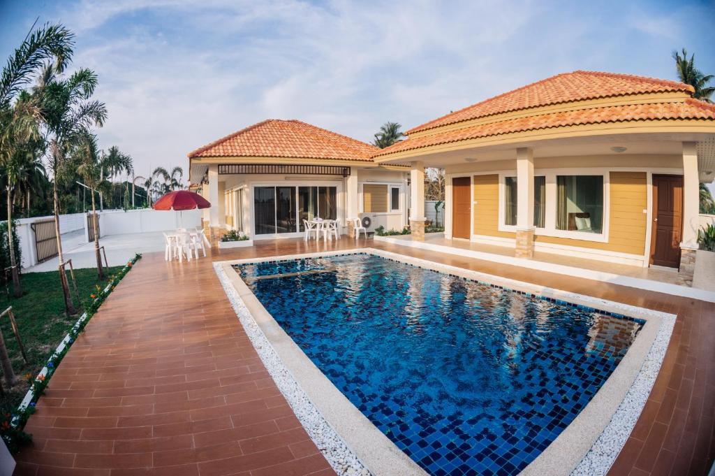 a house with a swimming pool in front of a house at The Legacy Huahin Pool Villa in Hua Hin