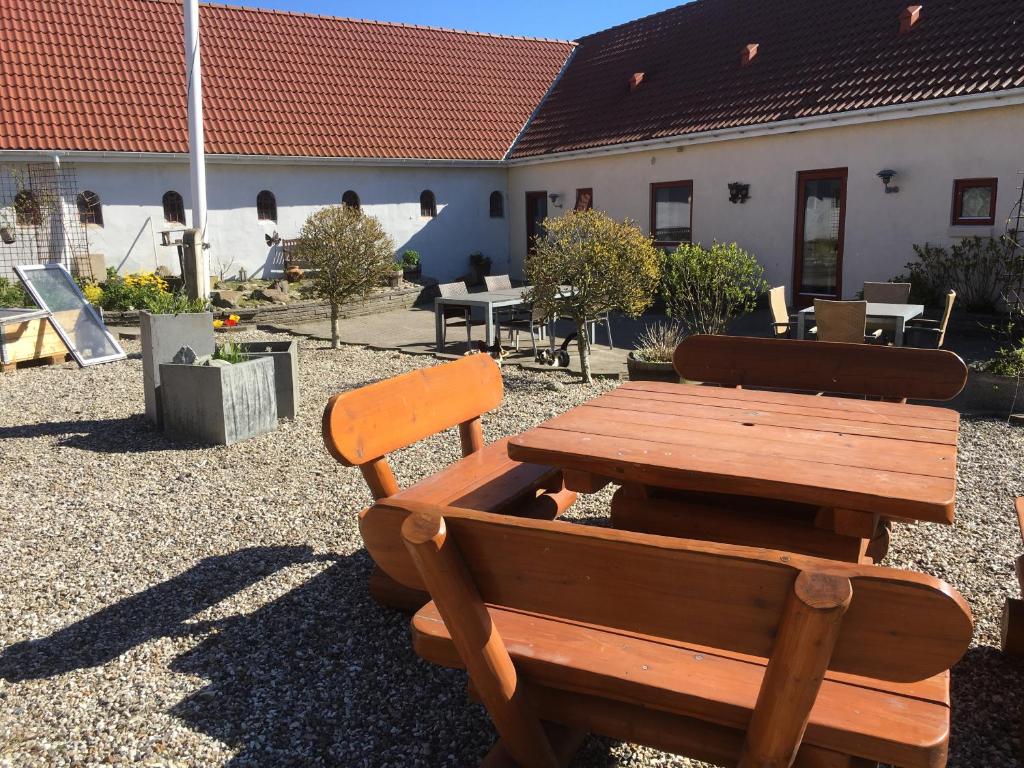 a wooden bench and a table in a yard at B & B Langagergaard in Thisted