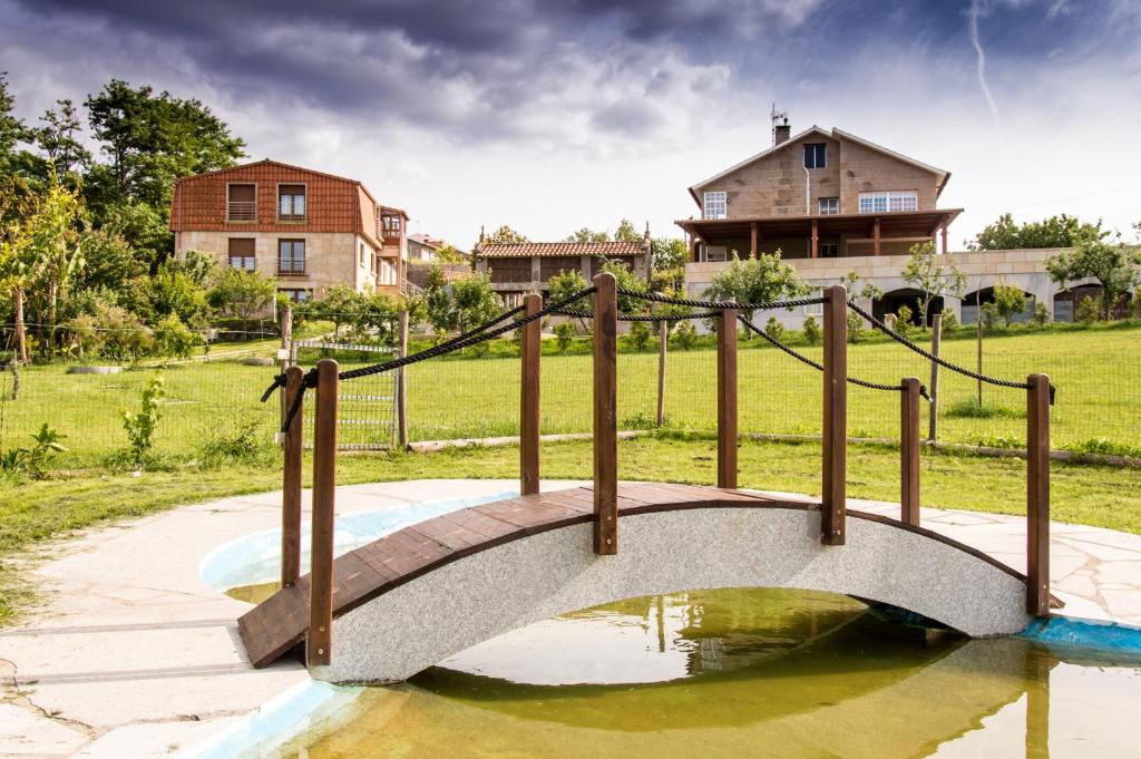 a bridge in a yard with a house in the background at Casa Codesal in Noalla