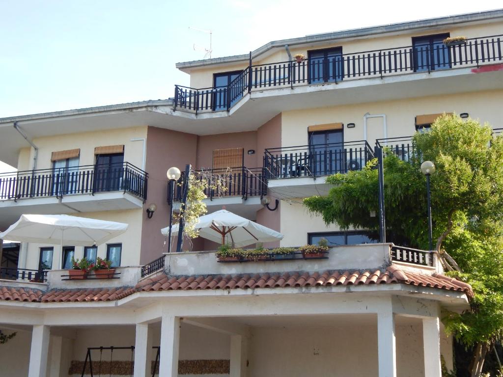 un gran edificio blanco con balcones y árboles en B&B La Meta, en Settefrati