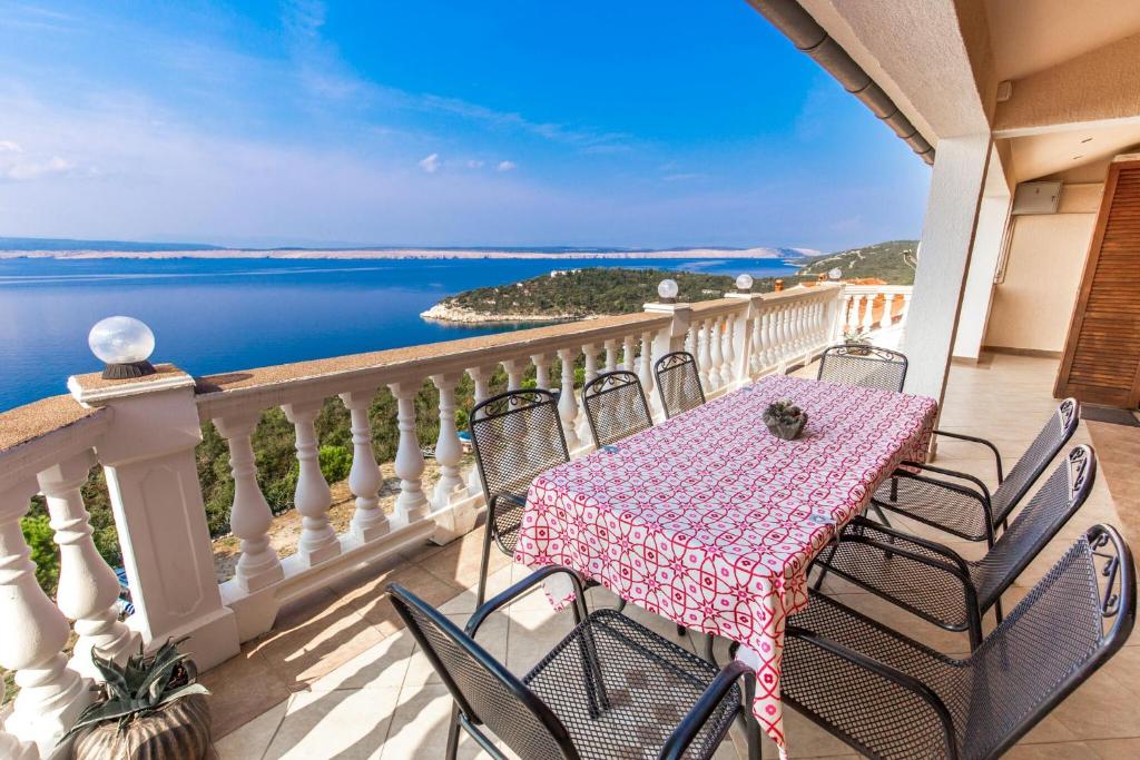 einen Tisch und Stühle auf einem Balkon mit Blick auf das Wasser in der Unterkunft Apartment Eli Kacjak in Dramalj