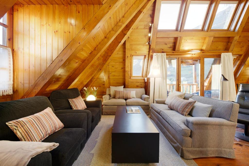 una sala de estar con sofás y una mesa en una cabaña en Besiberri by FeelFree Rentals, en Garós