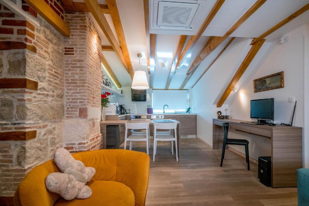 een woonkamer met een gele bank en een keuken bij Apartment Atticus in Split