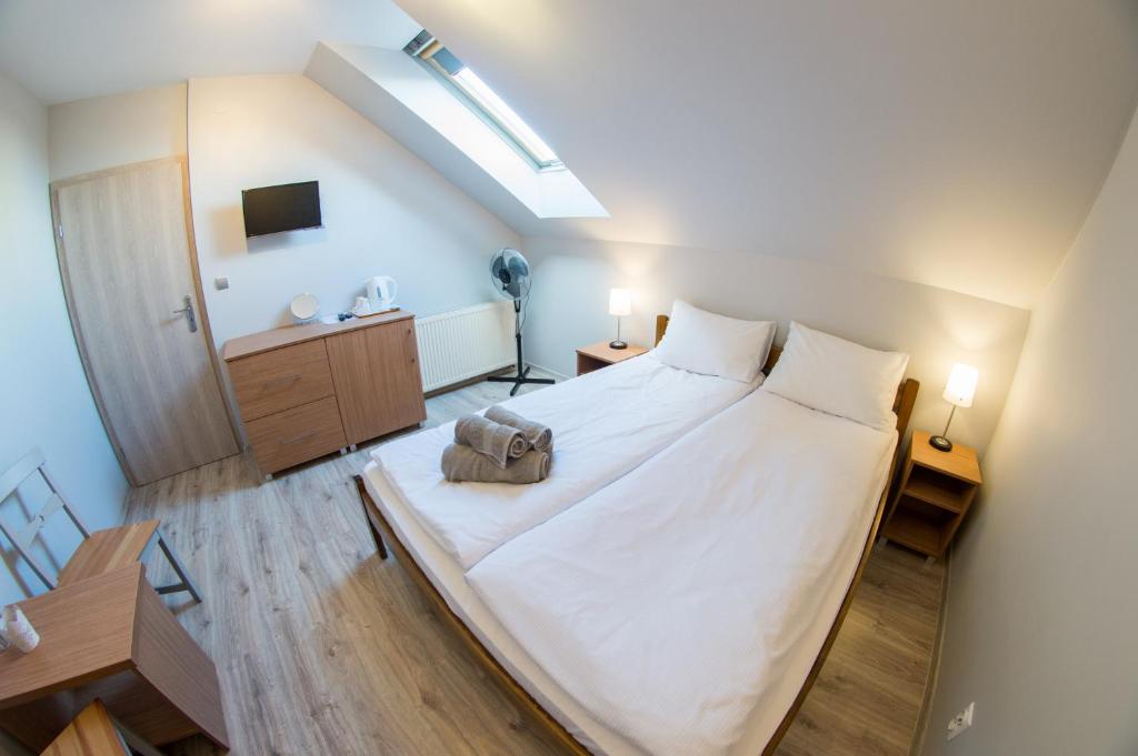een slaapkamer met een groot wit bed in een kamer bij Pokoje Złota Rybka in Mikołajki