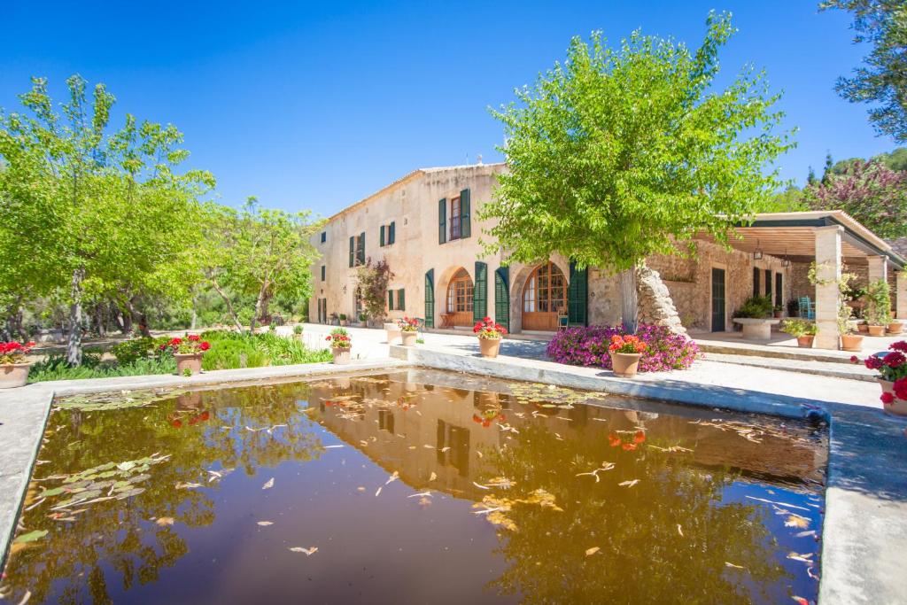 a courtyard with a pond in front of a building at Agroturismo Son Not in Artá