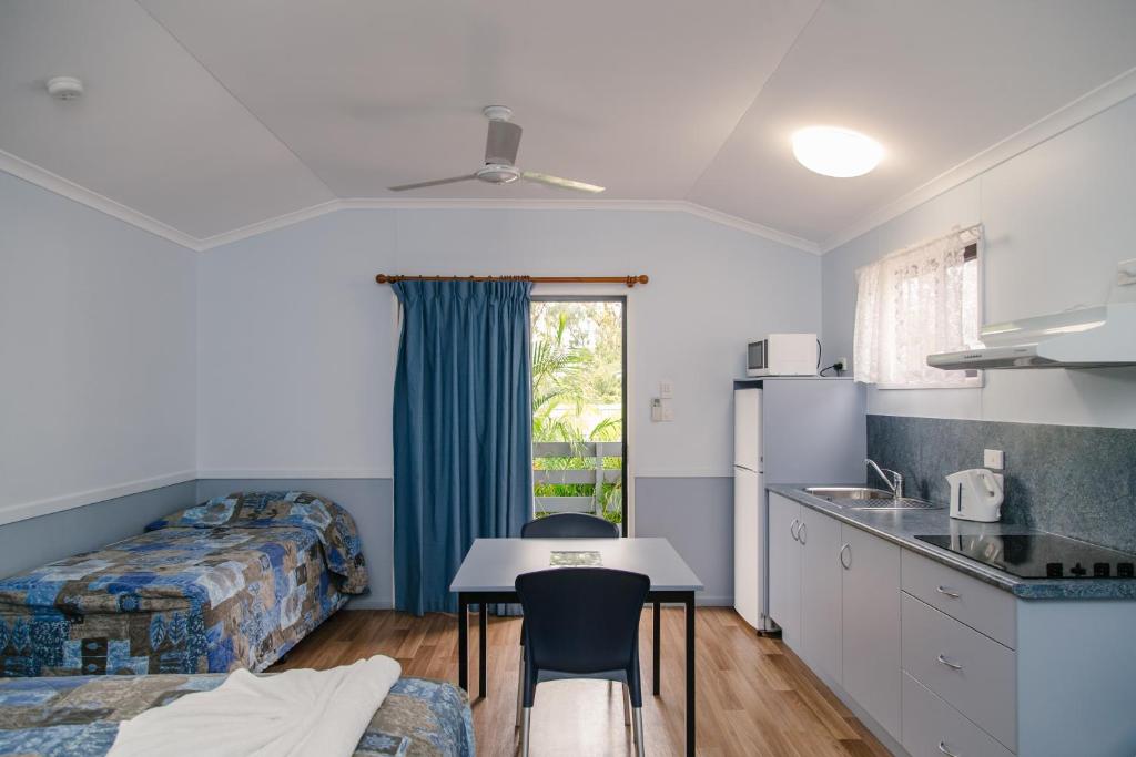 a room with a kitchen and a bed and a table at Southside Holiday Village in Rockhampton