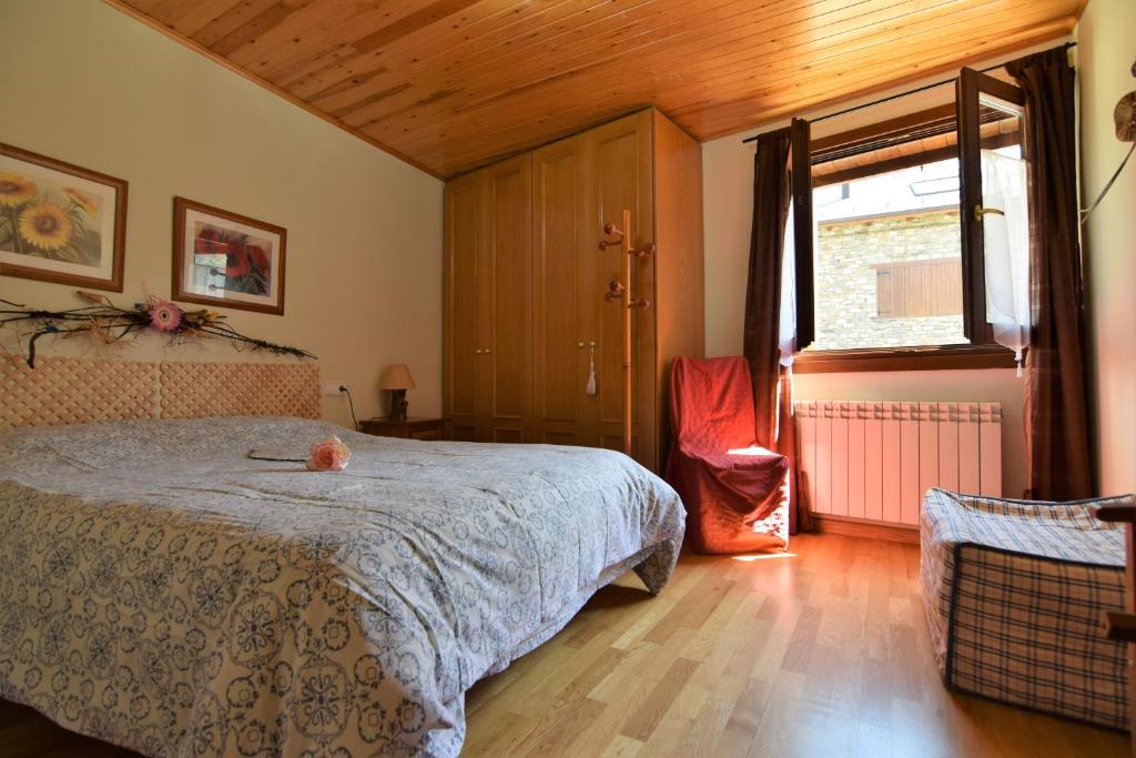 - une chambre avec un lit et une grande fenêtre dans l'établissement Apartamentos L´Era de Baix, à Barruera