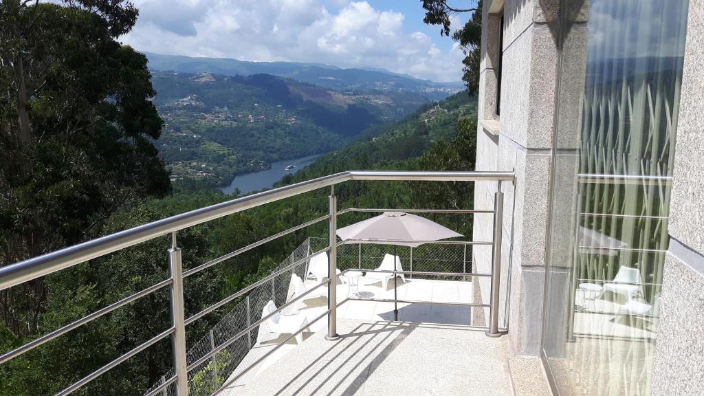 uma varanda com uma mesa e um guarda-chuva em Casa Douro Terrace em Baião