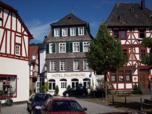Liebezeit - ehemals Hotel Dillenburg في ديلنبورغ: مبنى في بلدة فيه سيارات متوقفة أمامه