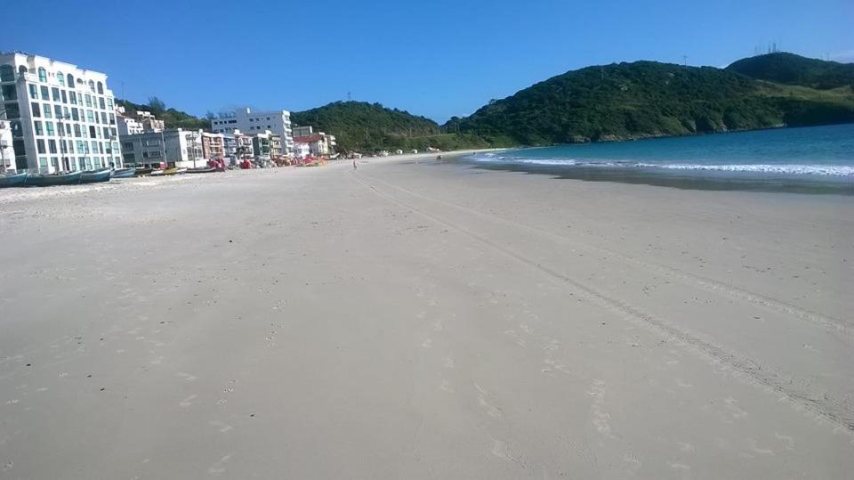 una playa vacía con edificios y el océano en Casa Do Junior Na Prainha Em Arraial Do Cabo, en Arraial do Cabo