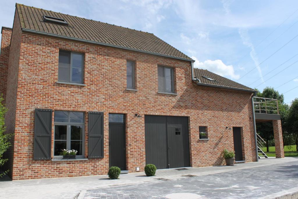 une maison en briques rouges avec deux portes de garage dans l'établissement B&B 't Hoogste, à Bornem