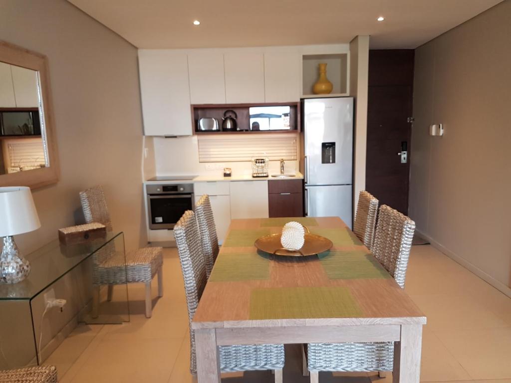 a kitchen and dining room with a table and chairs at Zimbali Suites 304 in Ballito