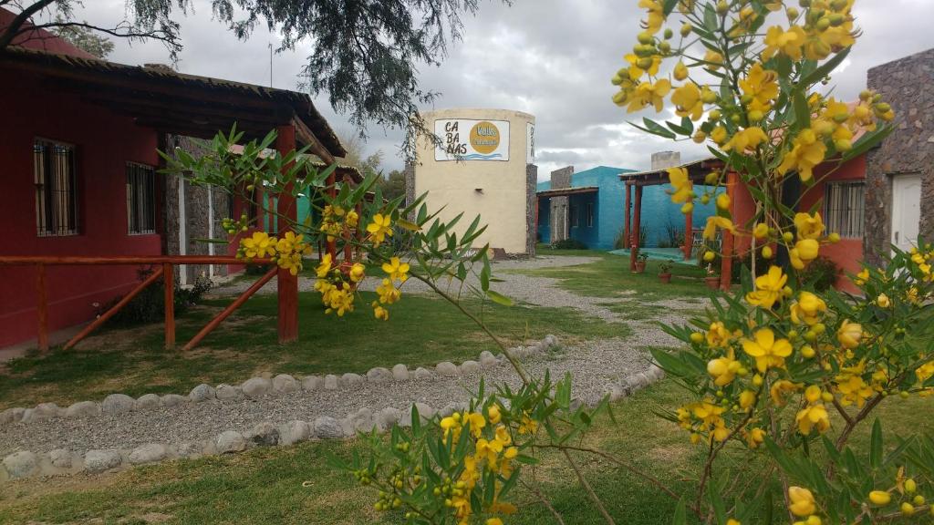 a street with yellow flowers in front of a building at Cabañas Valles Calchaquíes in Santa María