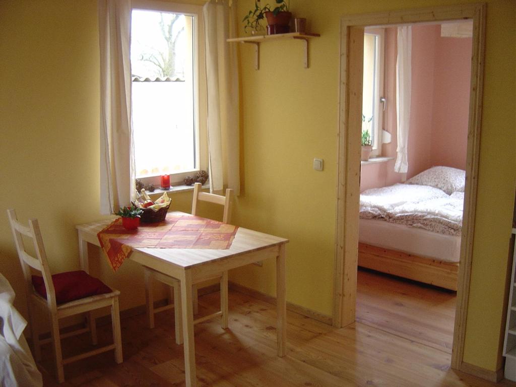 a room with a table and a bedroom with a bed at Fewo DD- Wilschdorf in Dresden